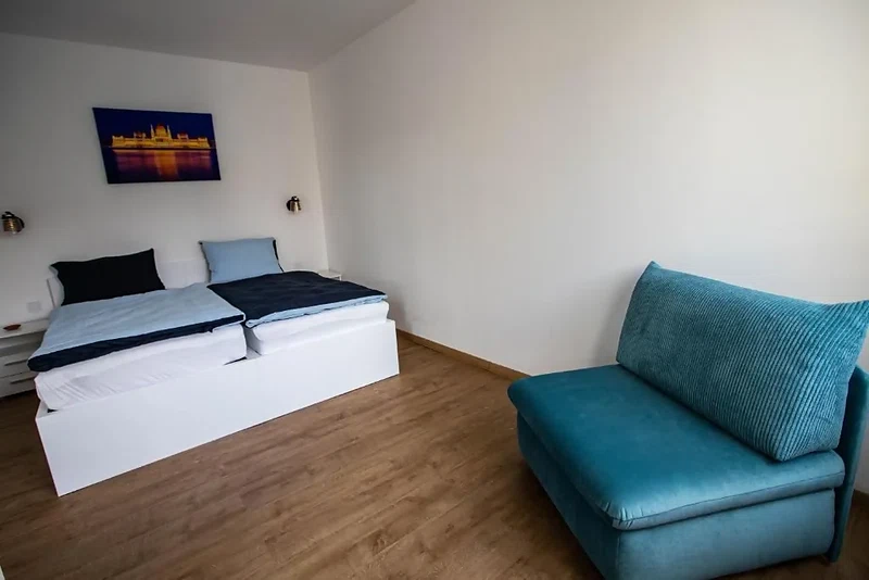 Flat Margaret hálószobája kényelmes ággyal és kék kanapéval